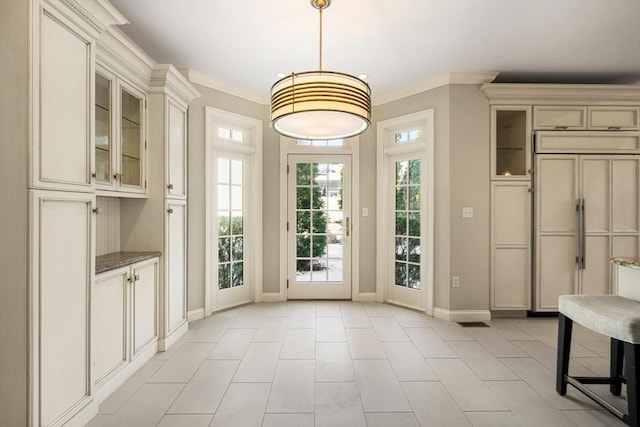 doorway to outside with ornamental molding and light tile patterned floors