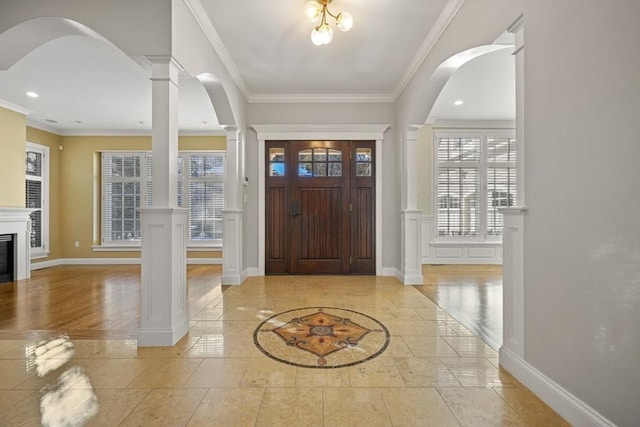 foyer with decorative columns and ornamental molding