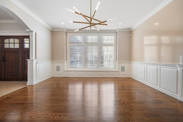 unfurnished dining area with crown molding, hardwood / wood-style floors, and a notable chandelier