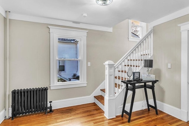 stairs featuring radiator heating unit and wood-type flooring