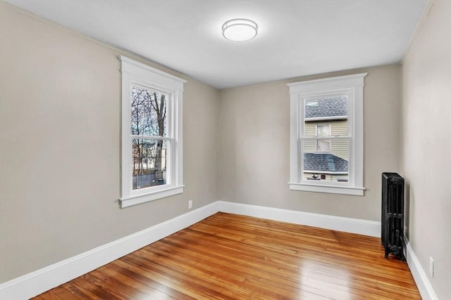 spare room with radiator and light hardwood / wood-style flooring