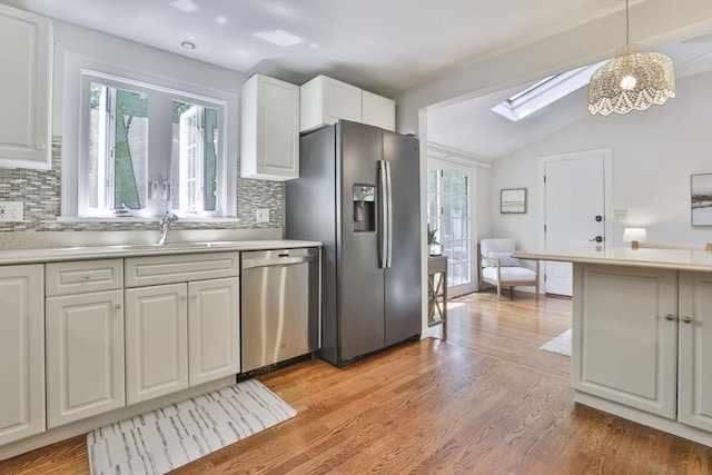 1 Columbine Rd, Milton, MA 02186 - kitchen with appliances with stainless steel finishes, a sink, a skylight, vaulted ceiling, and tasteful backsplash