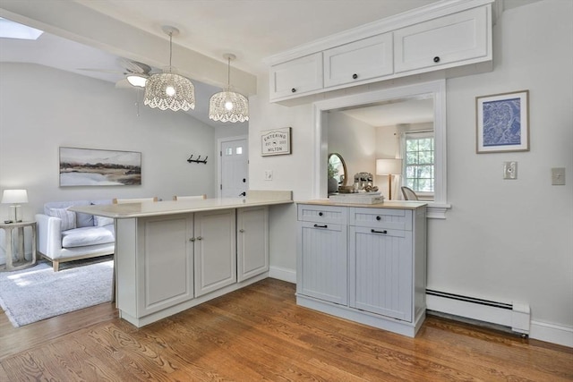 1 Columbine Rd, Milton, MA 02186 - kitchen featuring baseboard heating, a peninsula, vaulted ceiling, open floor plan, and wood finished floors