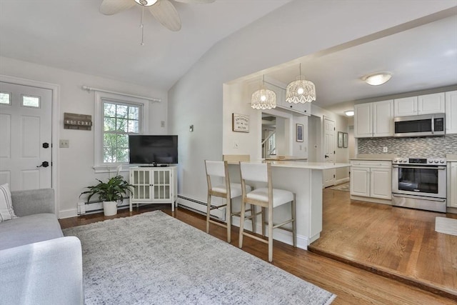 1 Columbine Rd, Milton, MA 02186 - kitchen featuring stainless steel appliances, lofted ceiling, light countertops, white cabinets, and wood finished floors