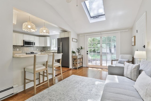 1 Columbine Rd, Milton, MA 02186 - living room featuring baseboard heating, lofted ceiling, wood finished floors, a skylight, and a chandelier