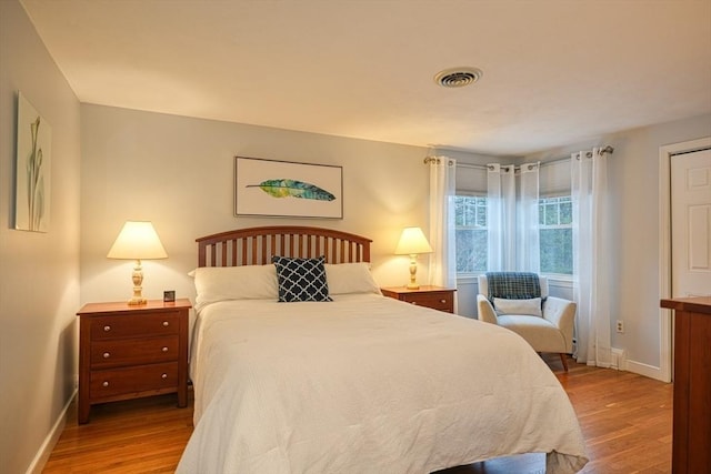 bedroom featuring light wood-style floors, baseboards, and visible vents