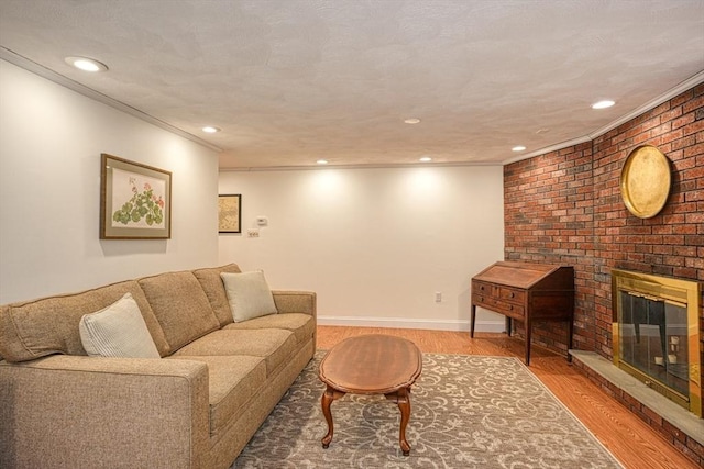 living room with baseboards, a fireplace, ornamental molding, and wood finished floors