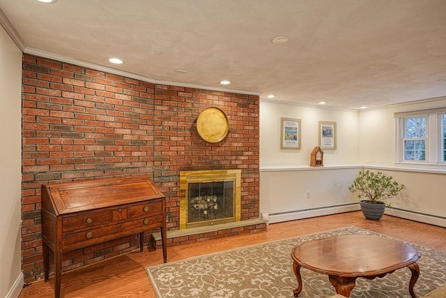 living room with a baseboard radiator, recessed lighting, ornamental molding, a brick fireplace, and light wood finished floors