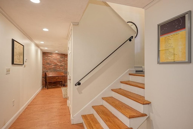 stairway with recessed lighting, baseboards, baseboard heating, and wood finished floors