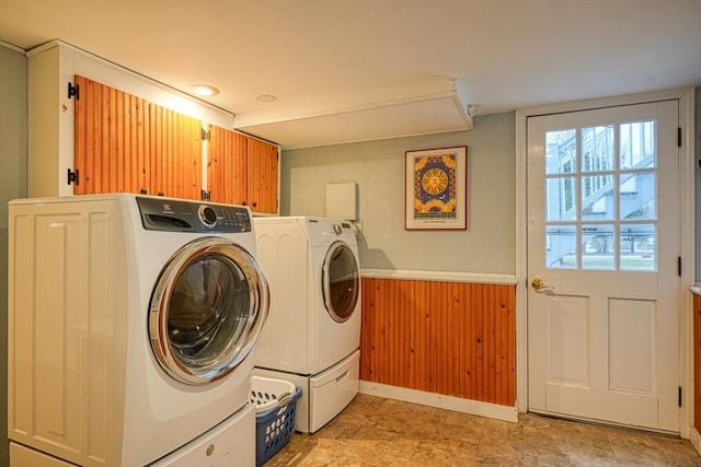 washroom featuring washing machine and dryer and cabinet space