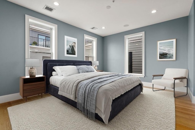 bedroom with baseboards, light wood finished floors, and recessed lighting