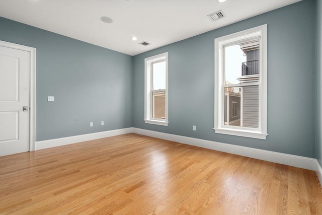 spare room with baseboards, light wood-type flooring, and recessed lighting