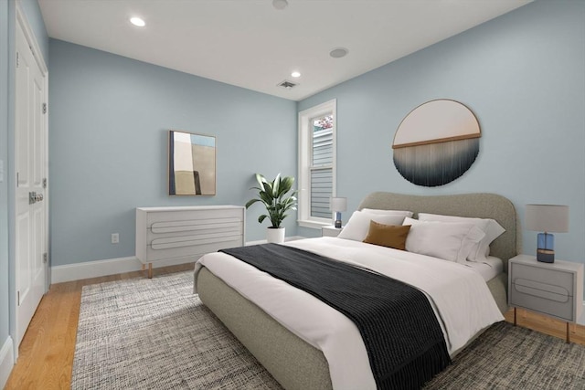 bedroom featuring wood finished floors, baseboards, and recessed lighting