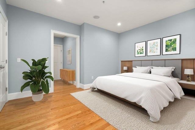 bedroom featuring baseboards, light wood-type flooring, and recessed lighting