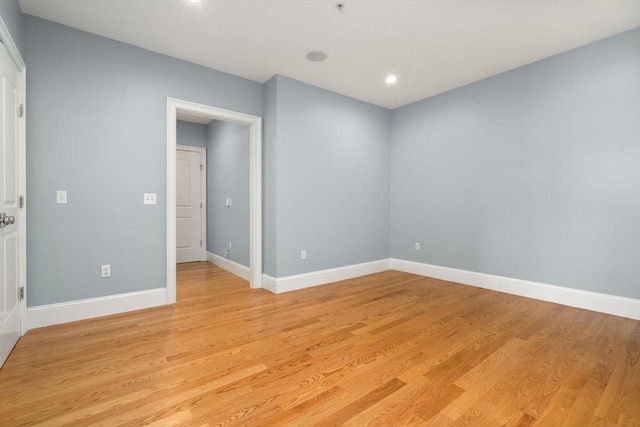 spare room featuring light wood-type flooring, recessed lighting, and baseboards