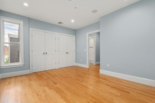 unfurnished bedroom featuring baseboards, light wood-type flooring, and recessed lighting