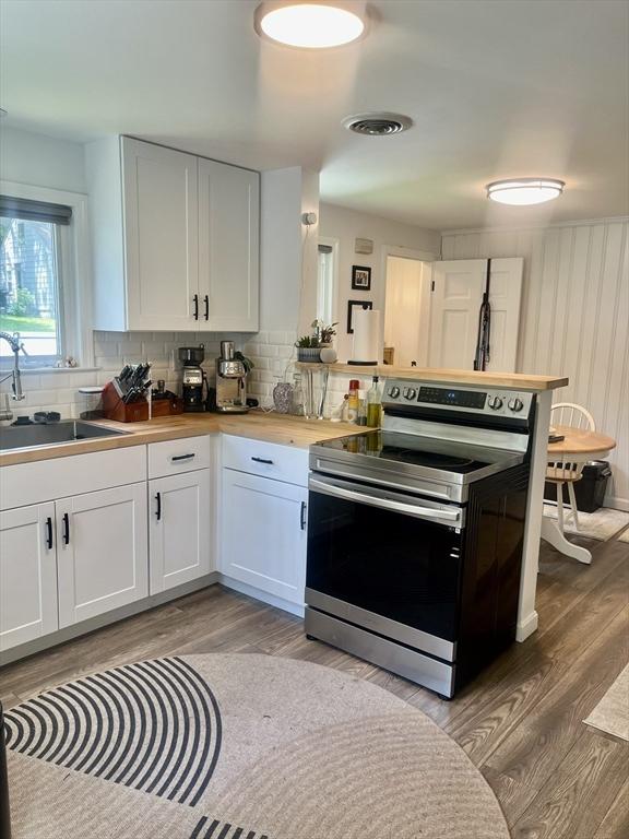 35 Marsh Ave, Worcester, MA 01605 - kitchen featuring stainless steel electric range, light wood-style flooring, decorative backsplash, and white cabinets