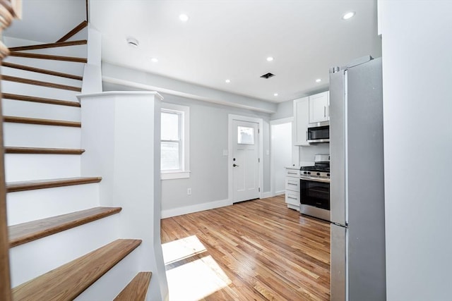 kitchen featuring light wood finished floors, stainless steel appliances, recessed lighting, visible vents, and white cabinetry