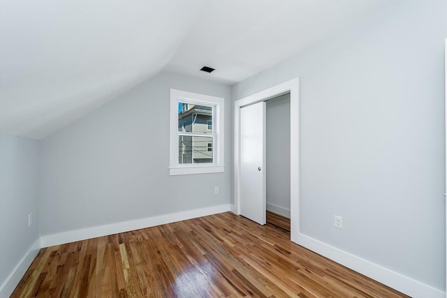 bonus room with vaulted ceiling, wood finished floors, and baseboards