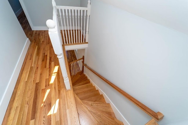 staircase featuring wood finished floors and baseboards