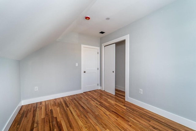 additional living space with lofted ceiling, baseboards, and wood finished floors