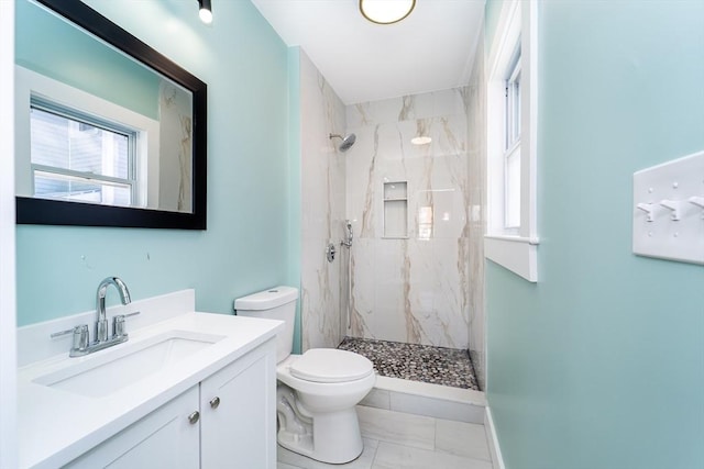 full bath featuring marble finish floor, vanity, a marble finish shower, and toilet