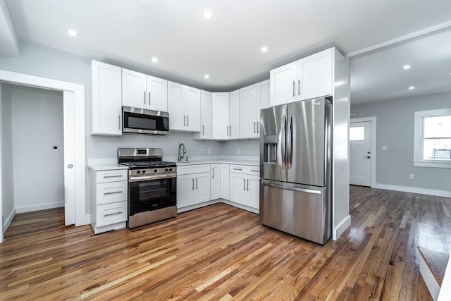 kitchen featuring light countertops, appliances with stainless steel finishes, a sink, and white cabinetry