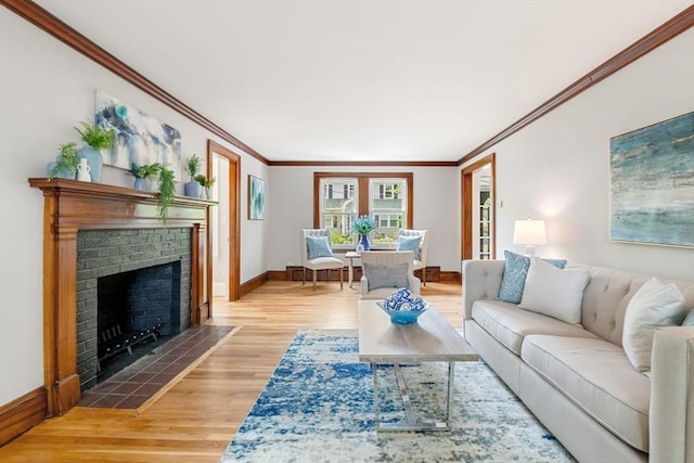 living room featuring crown molding, baseboards, wood finished floors, and a fireplace