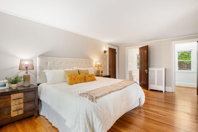 bedroom featuring crown molding, radiator, baseboards, and light wood-style floors