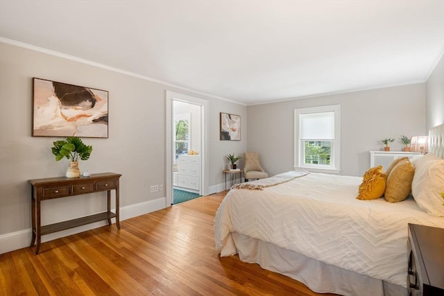 bedroom featuring crown molding, connected bathroom, baseboards, and wood finished floors