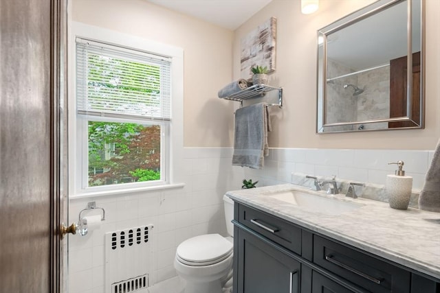 bathroom with walk in shower, toilet, tile walls, radiator heating unit, and vanity