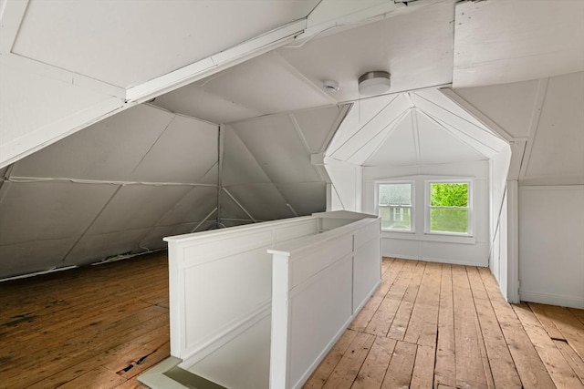 additional living space with lofted ceiling and light wood-style flooring