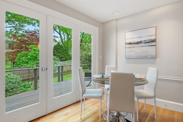 dining area featuring wood finished floors, french doors, and baseboards