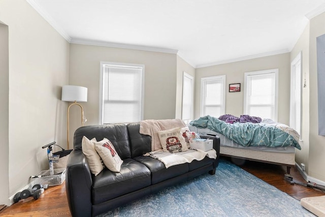 living area with baseboards, ornamental molding, and wood finished floors
