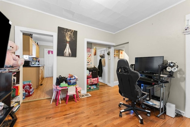 office space featuring light wood finished floors and ornamental molding