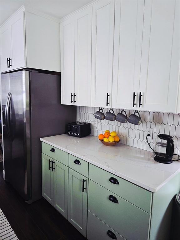 kitchen with tasteful backsplash and white cabinets