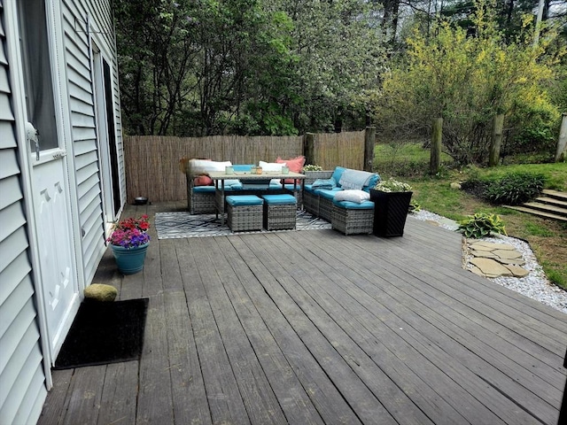 wooden terrace with an outdoor hangout area and fence