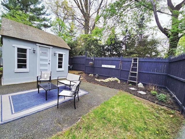fenced backyard with a patio area and an outbuilding