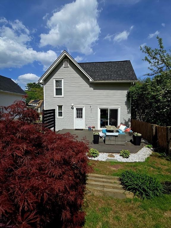 back of house with an outdoor living space, fence, a shingled roof, and a patio area