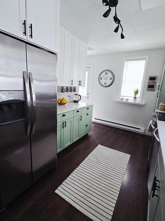kitchen with stainless steel fridge, a baseboard heating unit, dark wood-style flooring, light countertops, and white cabinetry