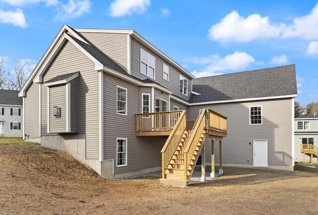 back of property featuring stairway, a wooden deck, and a shingled roof