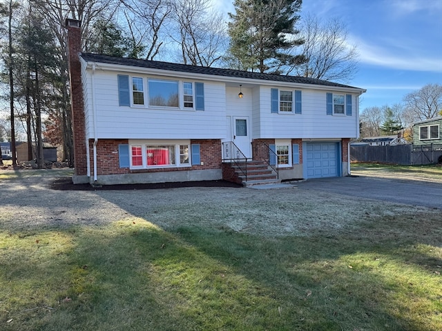 split foyer home featuring a front yard and a garage