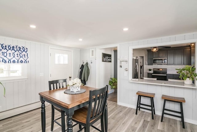 dining space featuring baseboard heating, ceiling fan, light wood finished floors, and recessed lighting