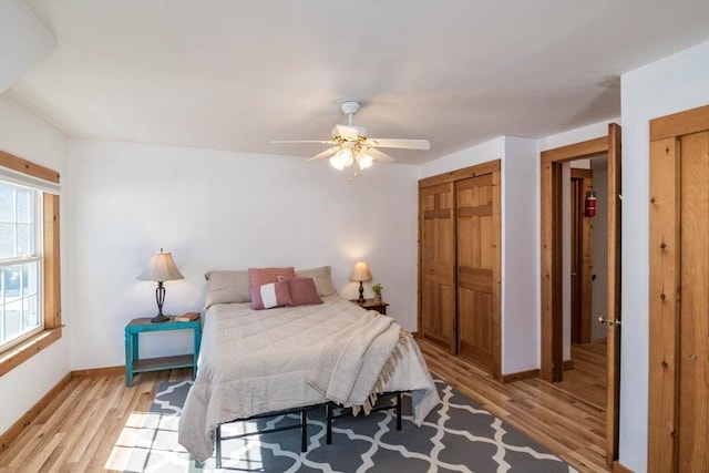 bedroom with light wood finished floors, a ceiling fan, and baseboards