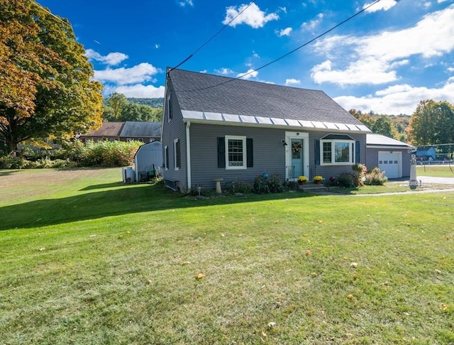 view of front of house with a garage, roof with shingles, and a front lawn