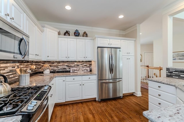 124 High Pine Cir Unit 124, Wilbraham, MA 01095 - kitchen with appliances with stainless steel finishes, backsplash, white cabinets, dark wood finished floors, and light stone countertops