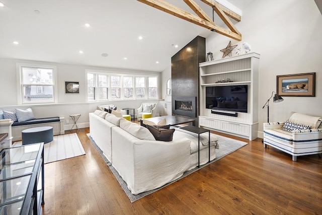 living room with a large fireplace, vaulted ceiling, wood finished floors, baseboards, and recessed lighting