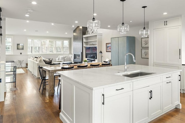kitchen featuring recessed lighting, a sink, an island with sink, and open floor plan