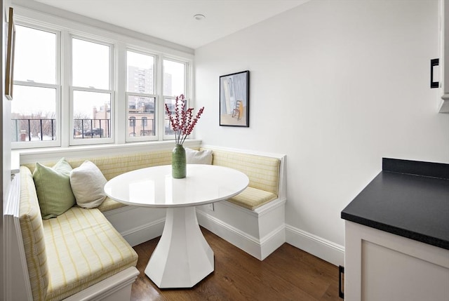 dining space featuring baseboards, wood finished floors, and breakfast area