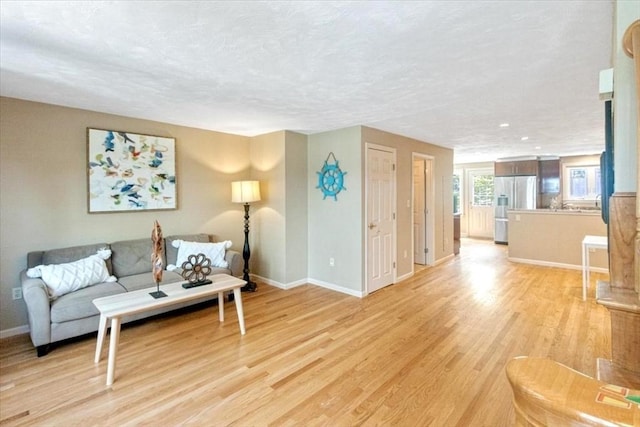 35 Merrymount Rd Unit 12, Quincy, MA 02169 - living area featuring light wood-style floors, baseboards, and a textured ceiling